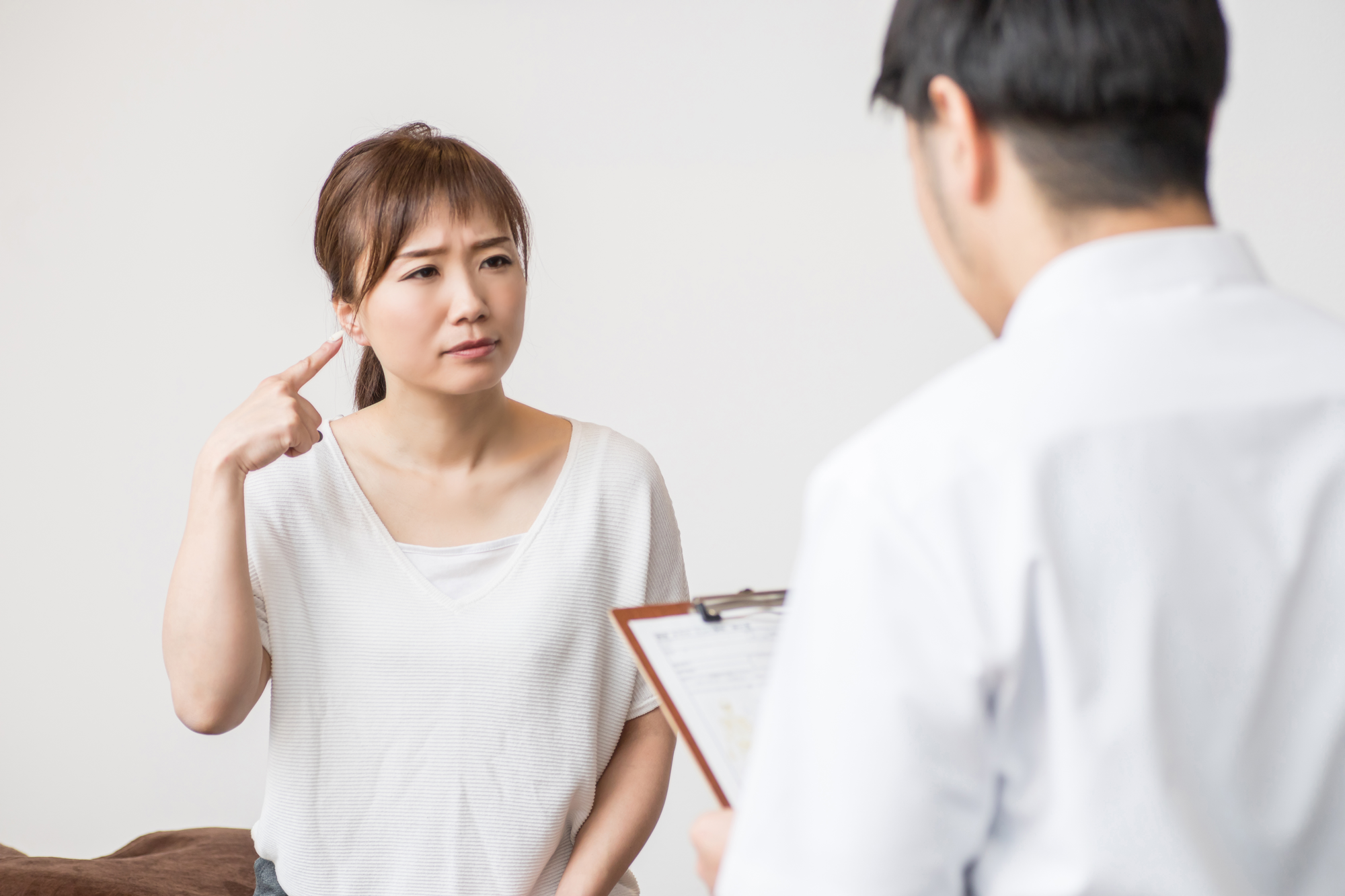 耳の違和感についてカウンセリングを受ける女性