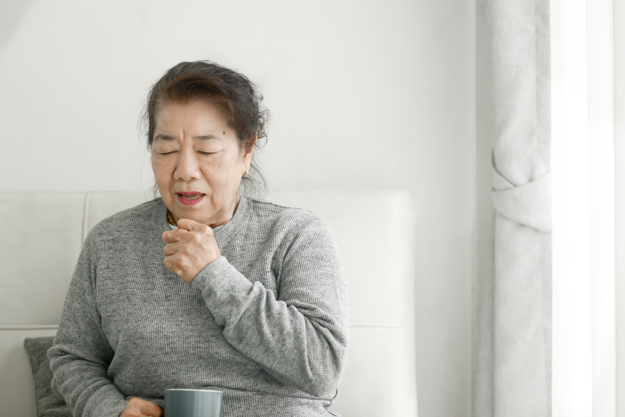 咳をする高齢者の女性
